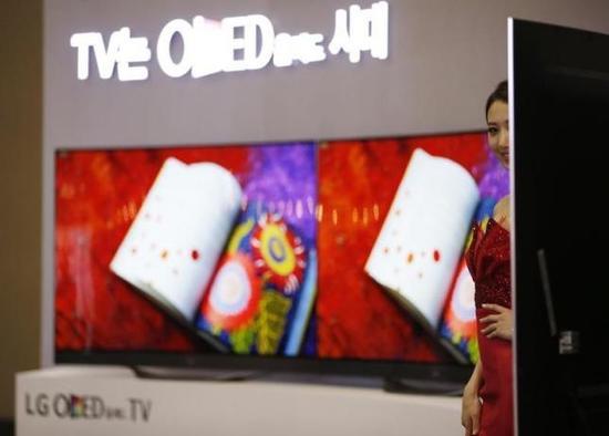 2014年韩国电子展，一名模特站在LG的曲屏电视机前。该电视的面板由LG Display生产。