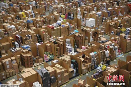 资料图：亚马逊仓库内，工作人员正忙着给商品装箱。